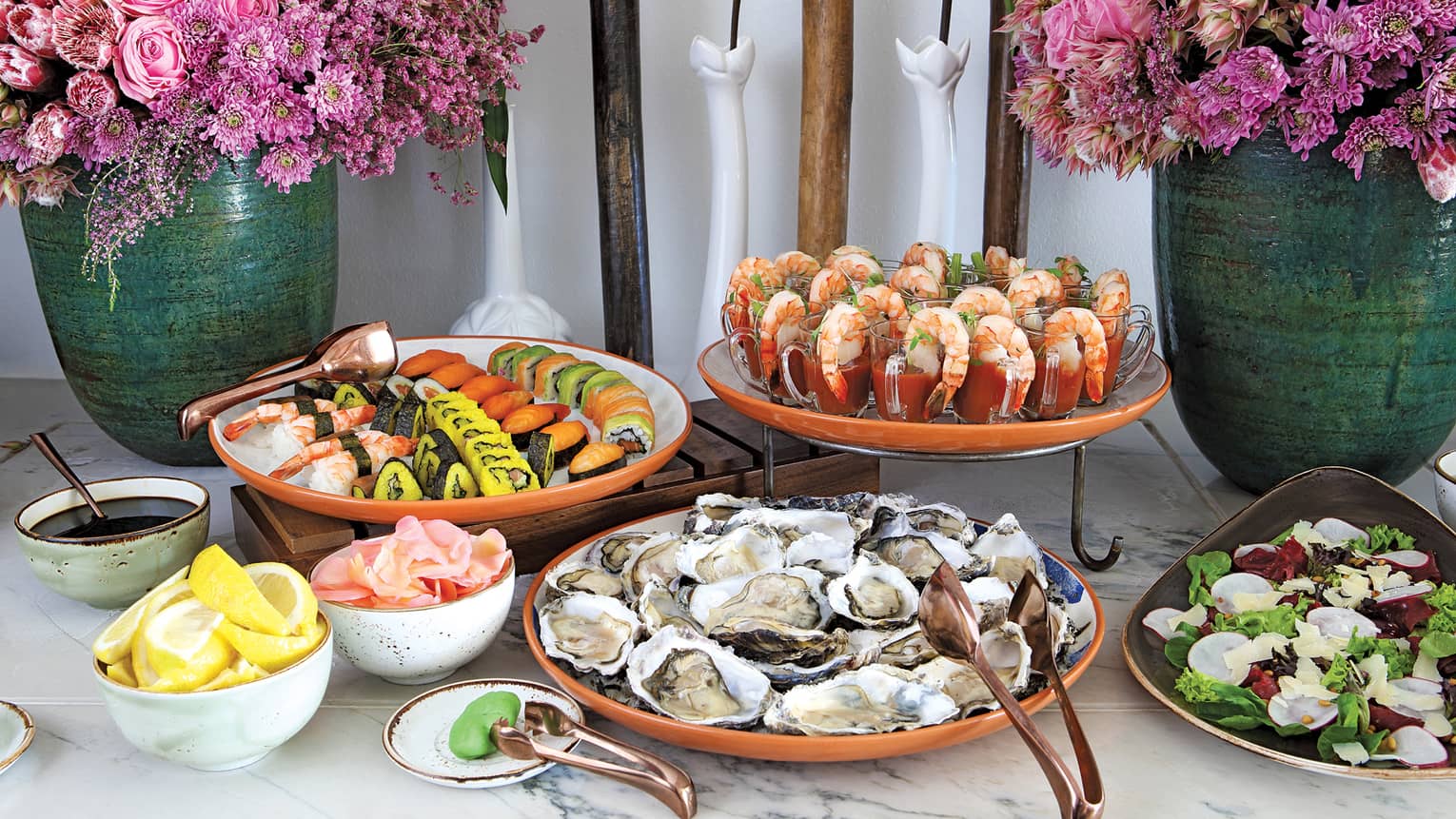 Table with flowers, platters with sushi, fresh oysters, shrimp cocktails