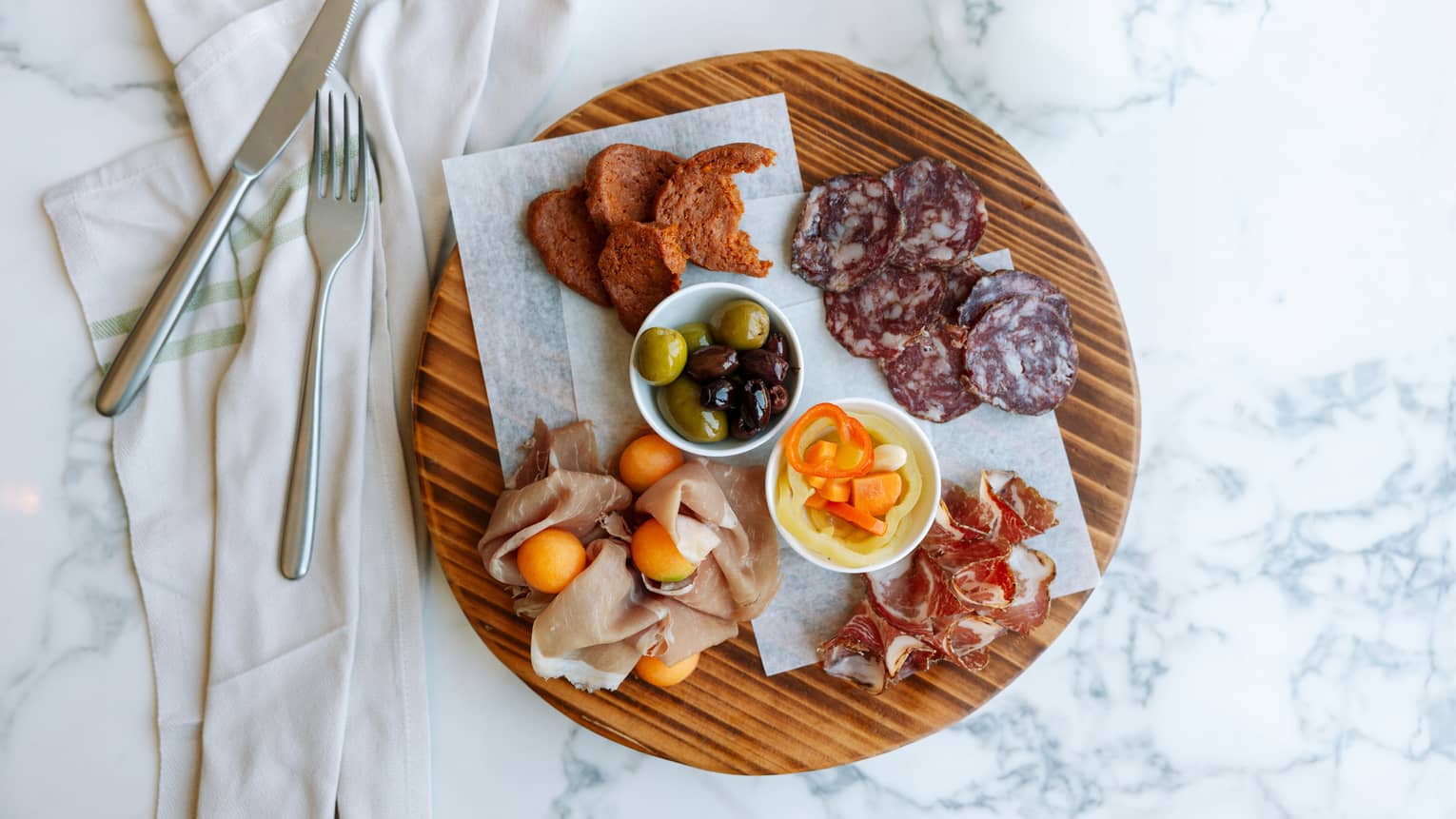 Charcuterie board with various meats.