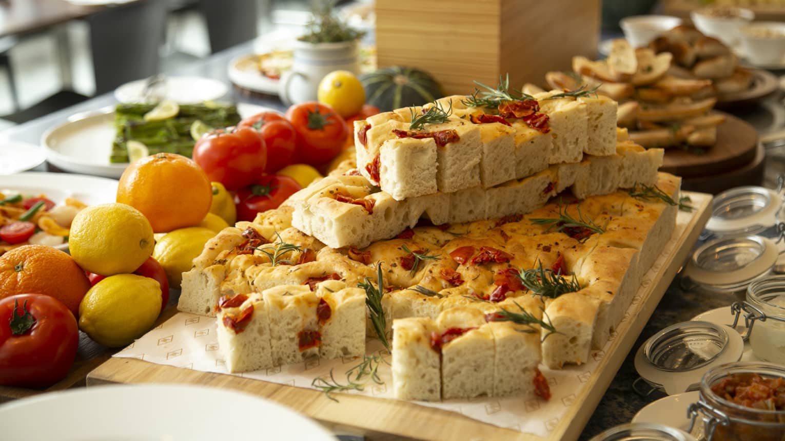 Slices of sun-dried tomato and rosemary focaccia on wooden serving board