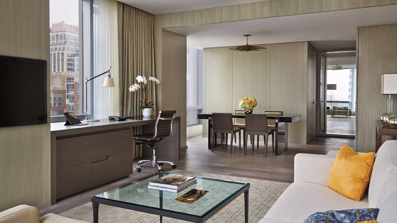 Yorkville Suite living room, glass table, desk under window, dining room by bedroom door