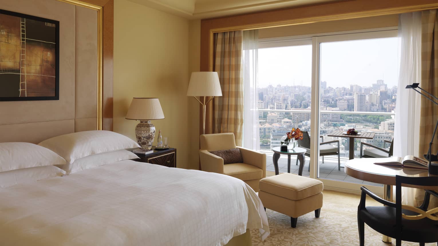Superior City-View Room with king-size bed, yellow armchair and ottoman, small table, patio doors with city view
