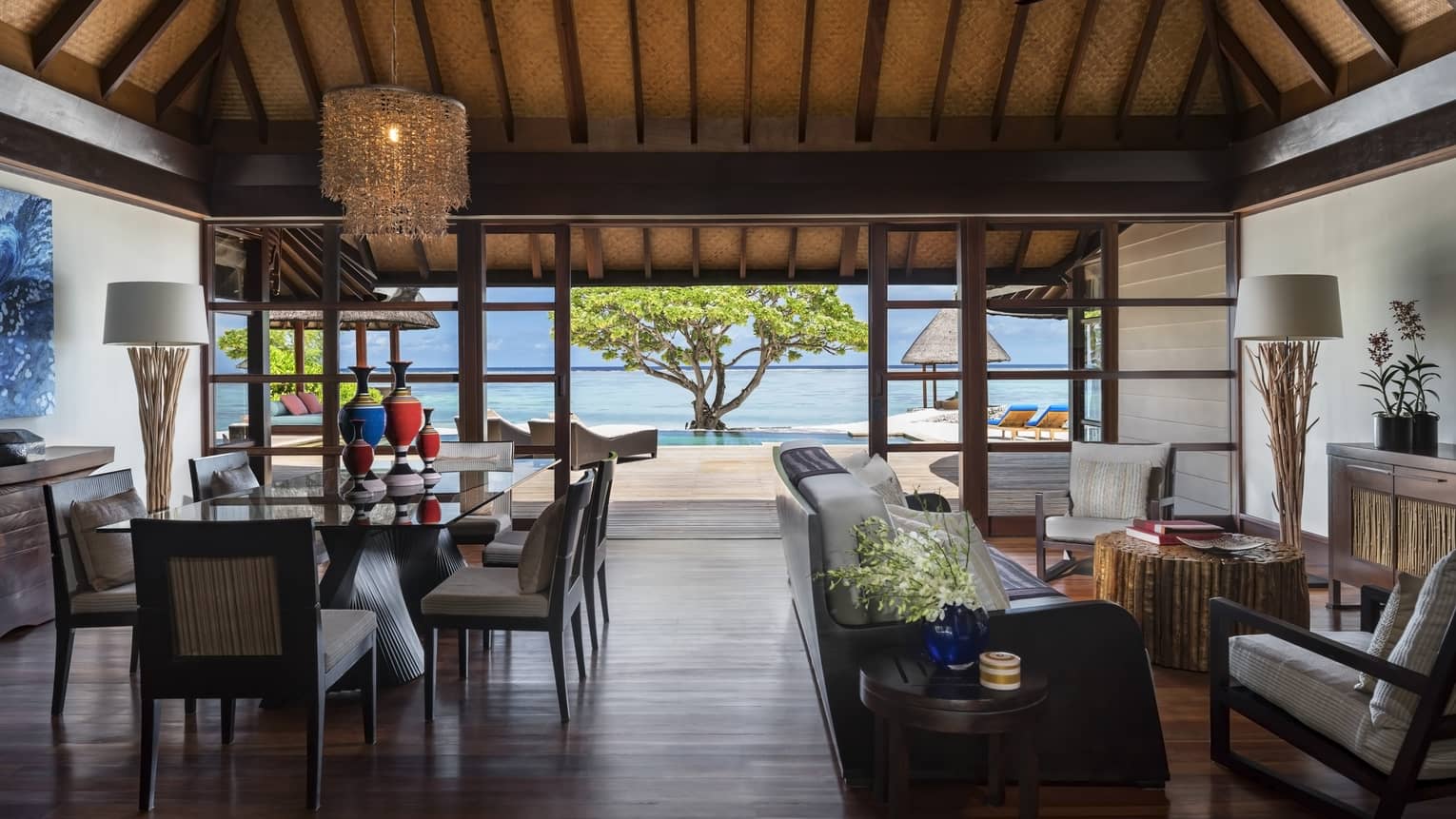 Wood-floored living room, opening up to the beach, of a Two-Bedroom Royal Beach Villa
