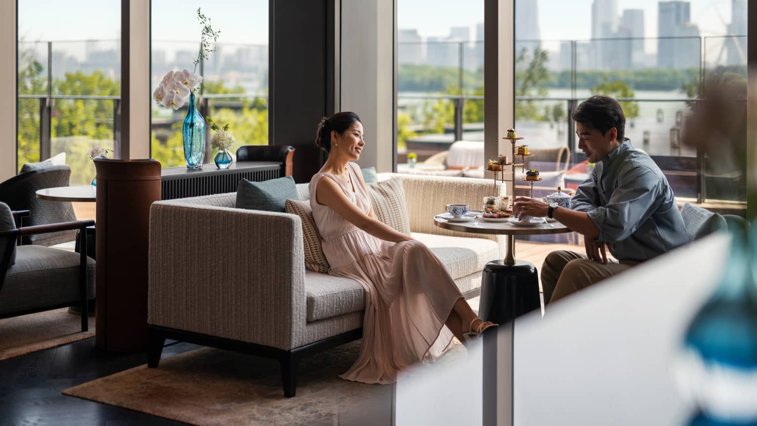 Man and woman enjoy afternoon tea at Lobby Lounge at luxury hotel