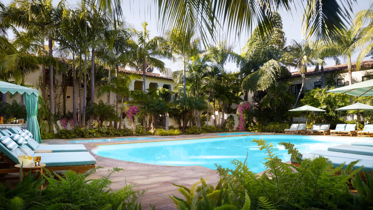 Tropical trees, plants, lounge chairs and cabanas around Jungle Pool