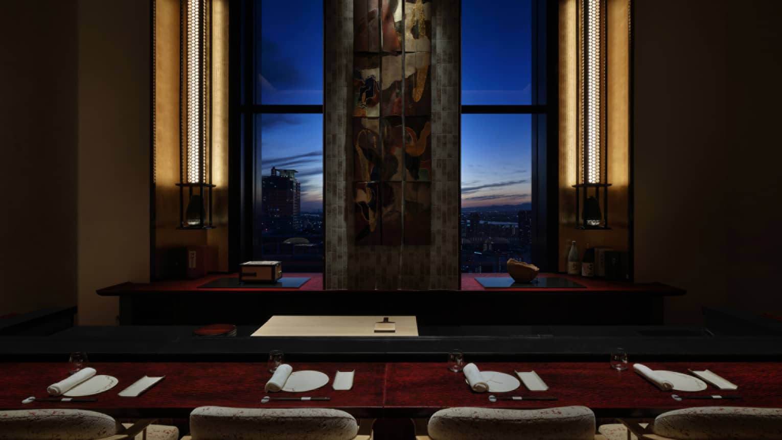 Elegant sushi counter at Sushi L’Abysse Osaka Yannick Alléno, overlooking the city skyline at sunset.