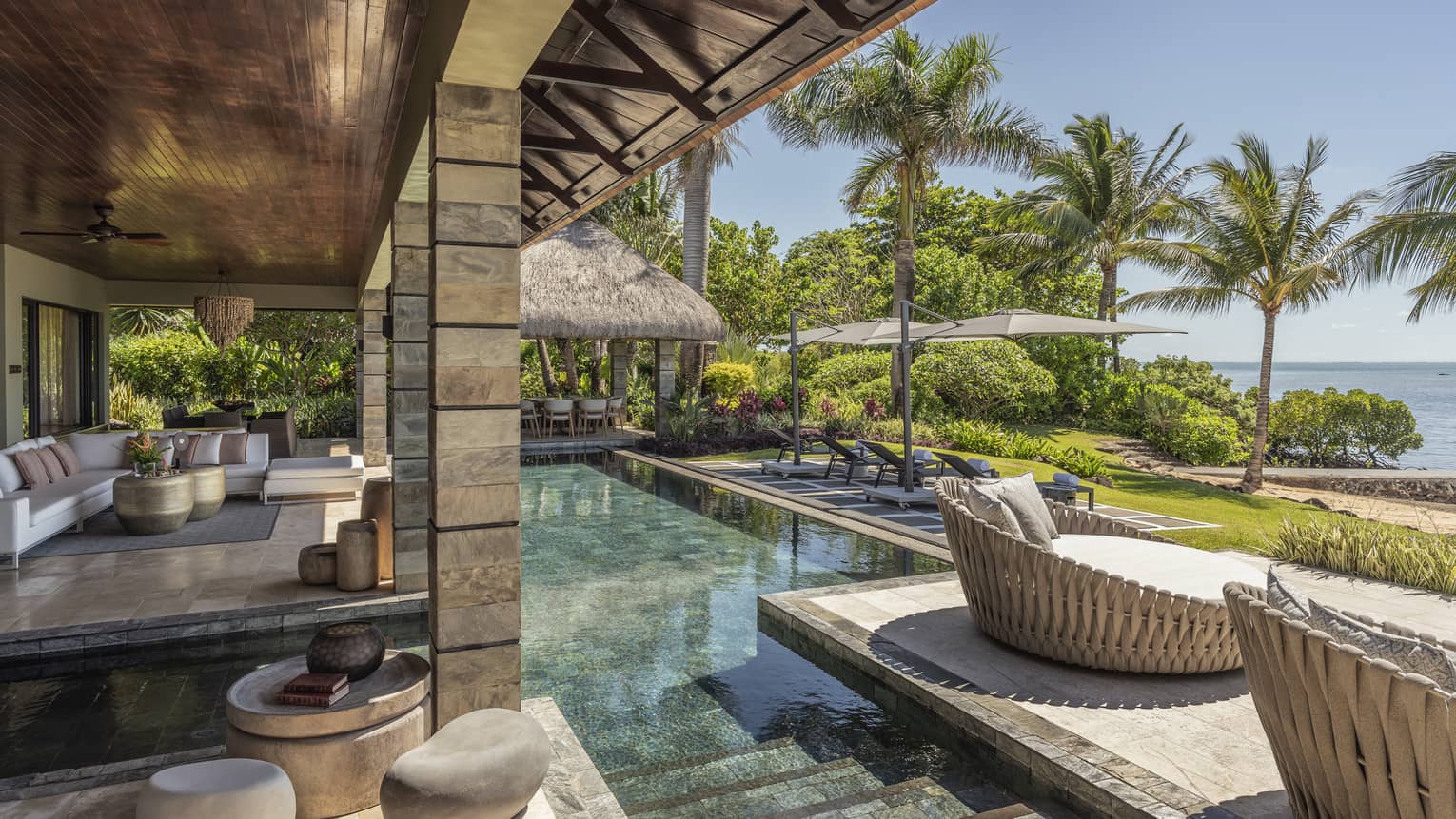 Stone, ocean-view terrace with pool, whicker day beds, pavilion covering