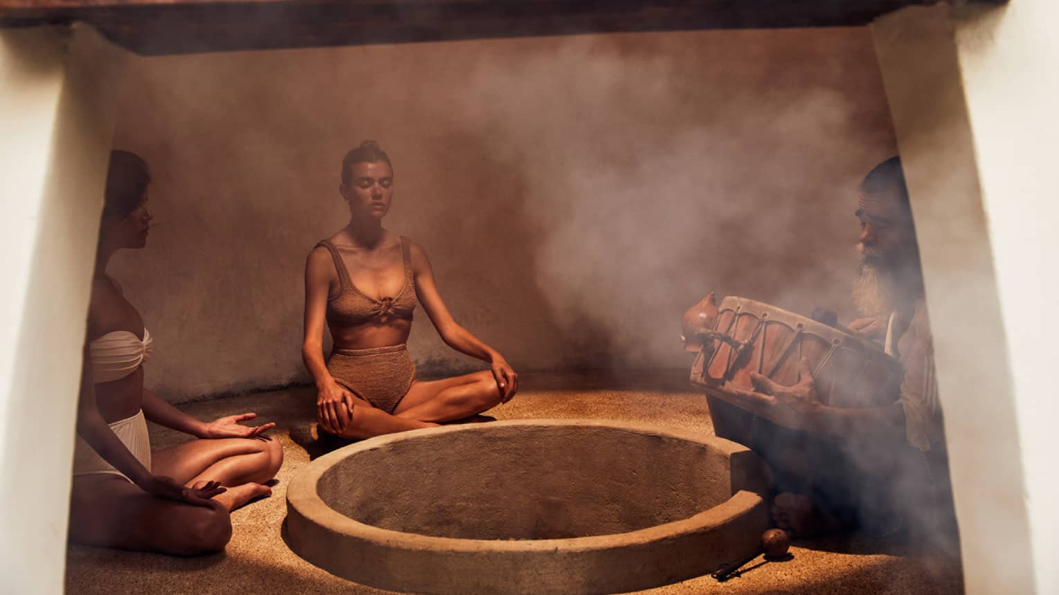 Three people sitting in a heated room with steam.