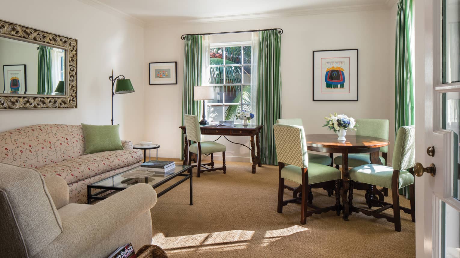 Palm Suite living room with sofa, mint-green dining chairs, desk chair, curtains