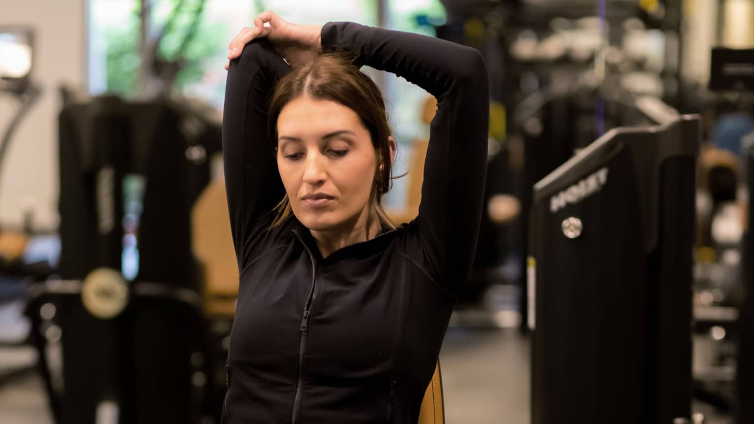 Guest stretching while sitting on an exercise machine.