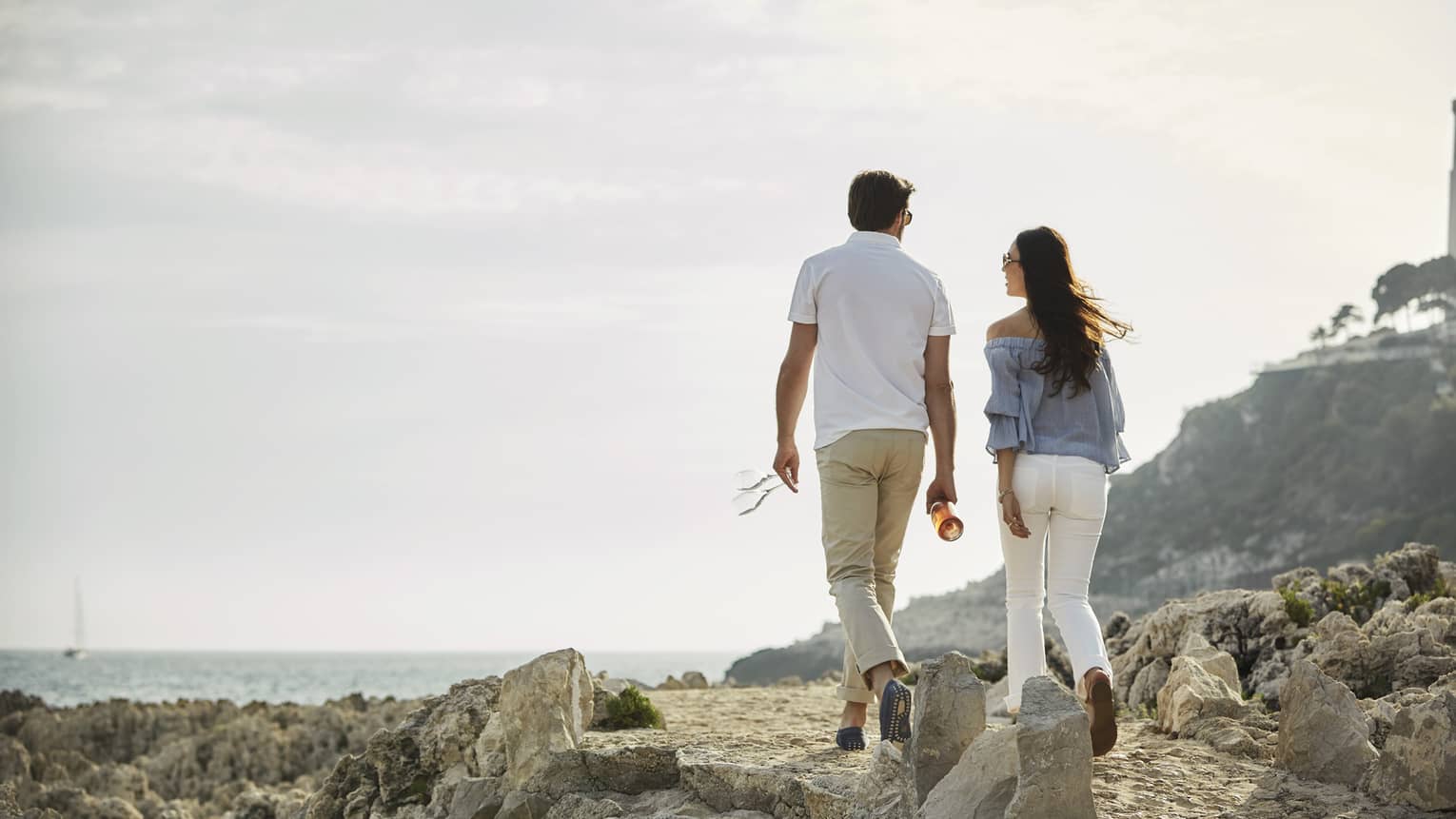 Back of couple walking across rocky trail on Saint-Jean Cap Ferrat Coastal Pathway