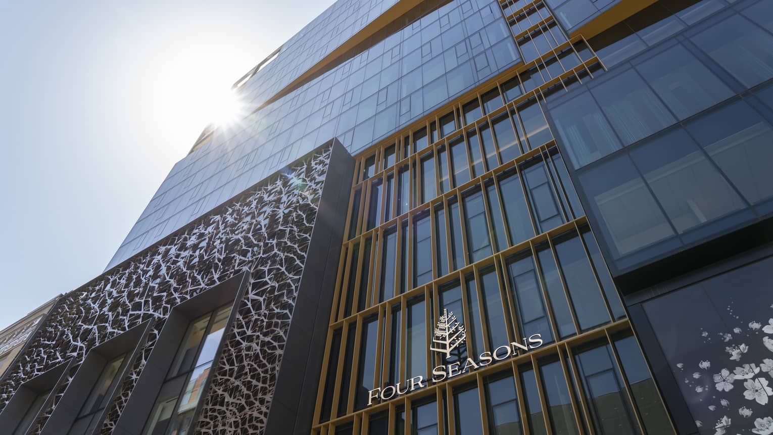A front view of the Four Seasons Montreal hotel, featuring the Art Deco design above the entrance. 