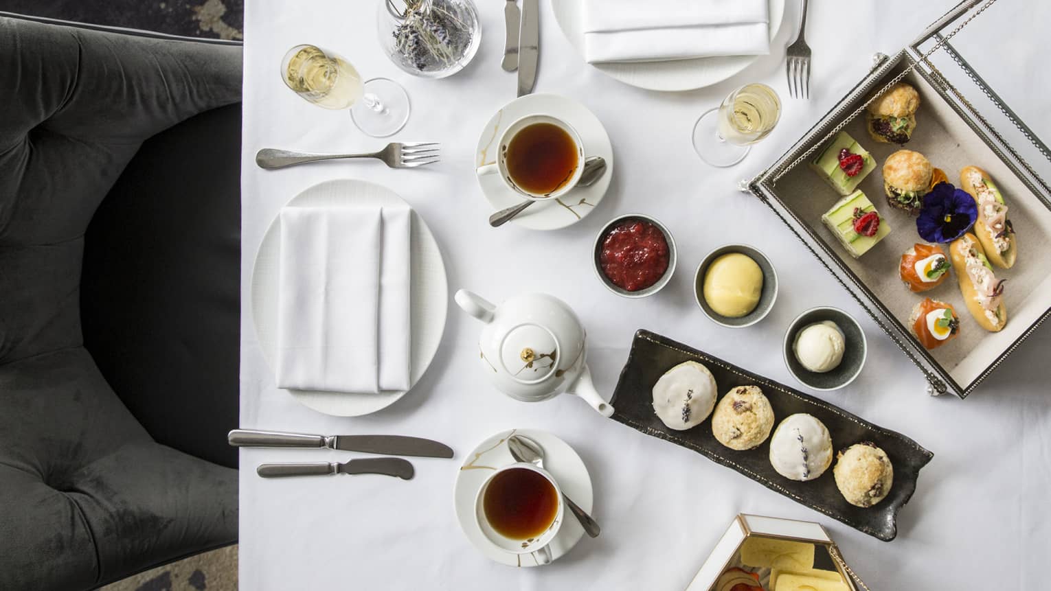 Aerial view of elegant afternoon tea display, complete with finger foods and condiments