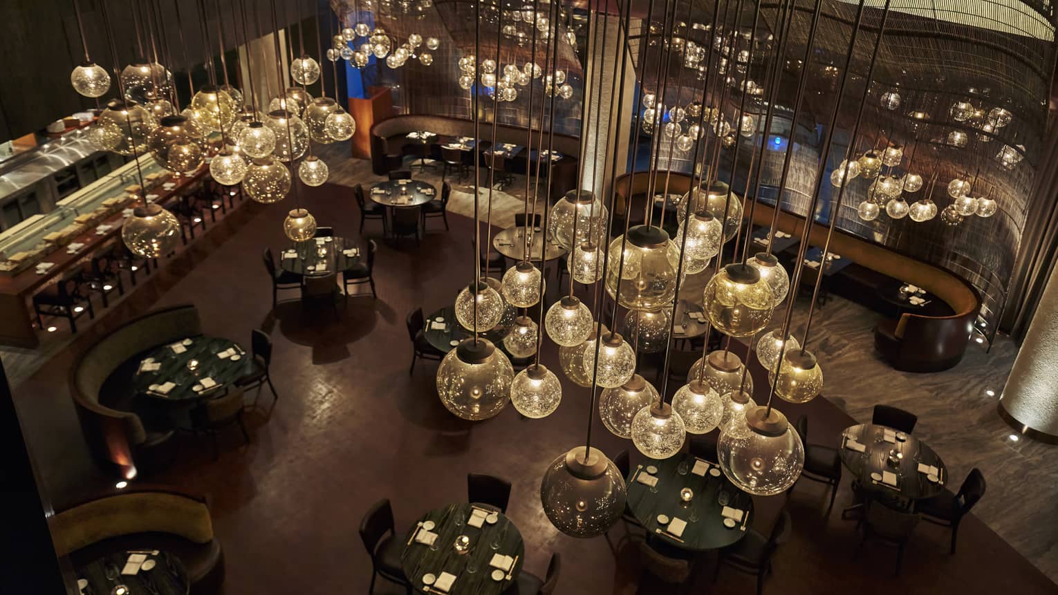 View from Nobu restaurant ceiling looking down at glass bulb chandeliers, dark dining room