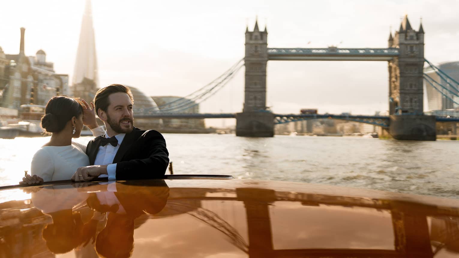 A couple enjoy on a romantic river cruise, surrounded by iconic city landmarks.