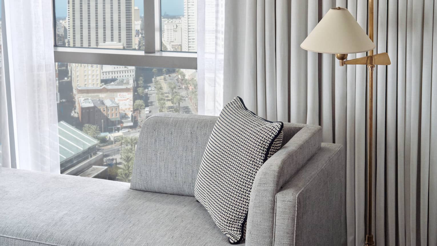 Deluxe City-View Room with grey chaise lounge, floor lamp, floor-to-ceiling window