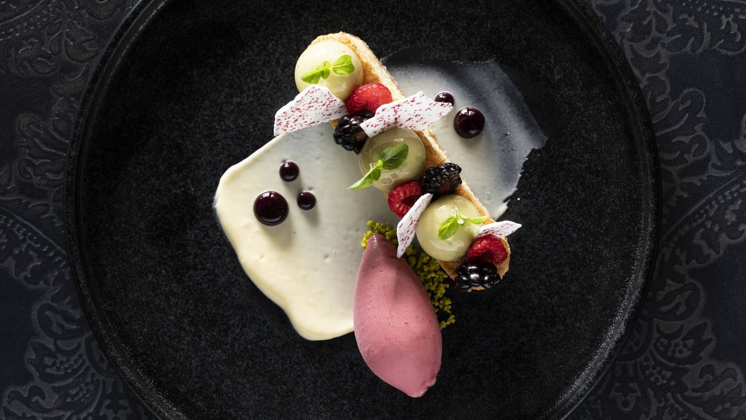 Olive oil cake paired with yuzu yogurt mousse, strawberry chip and mixed berry sorbet