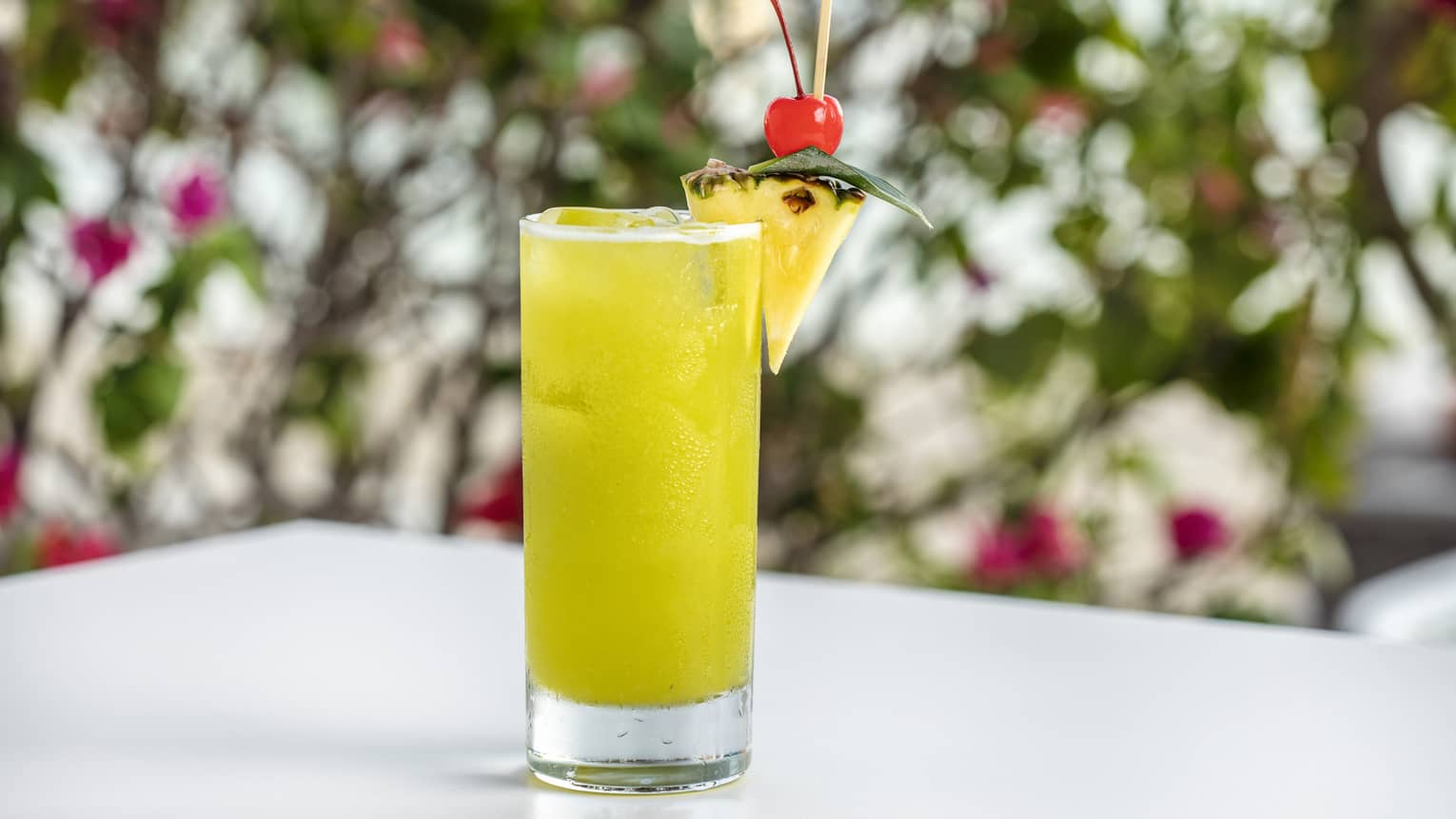 Seabreeze in a high ball glass garnished with a piece of pineapple and a cherry