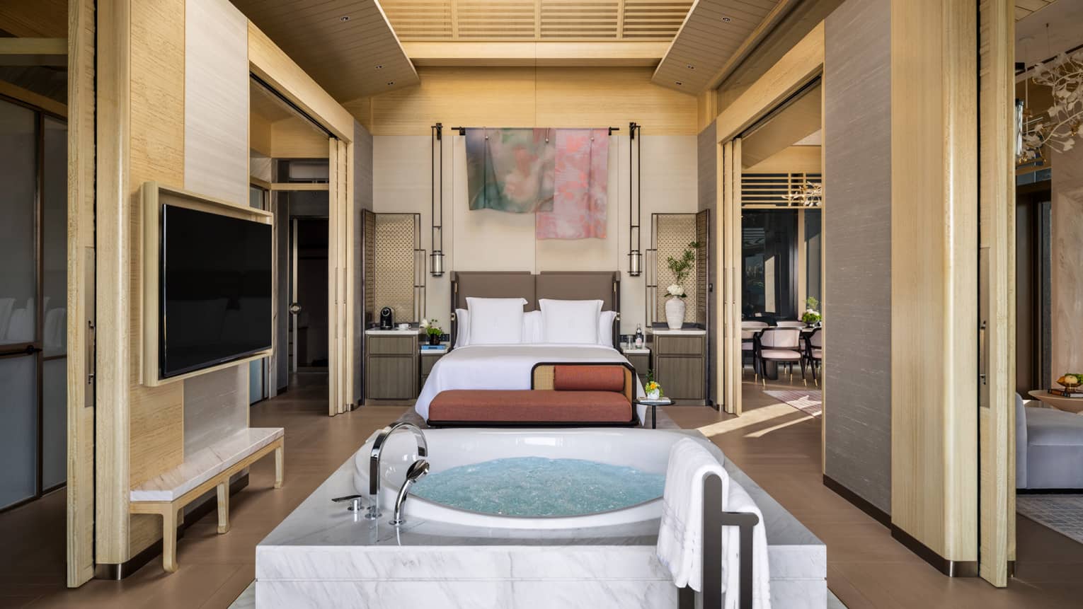 Luxury bedroom with king bed, TV, chaise and standalone spa tub in Penthouse Suite at Four Seasons Hotel Suzhou