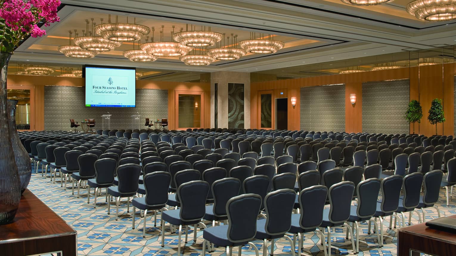 Atik Pasha Ballroom conference with rows of chairs facing large screen