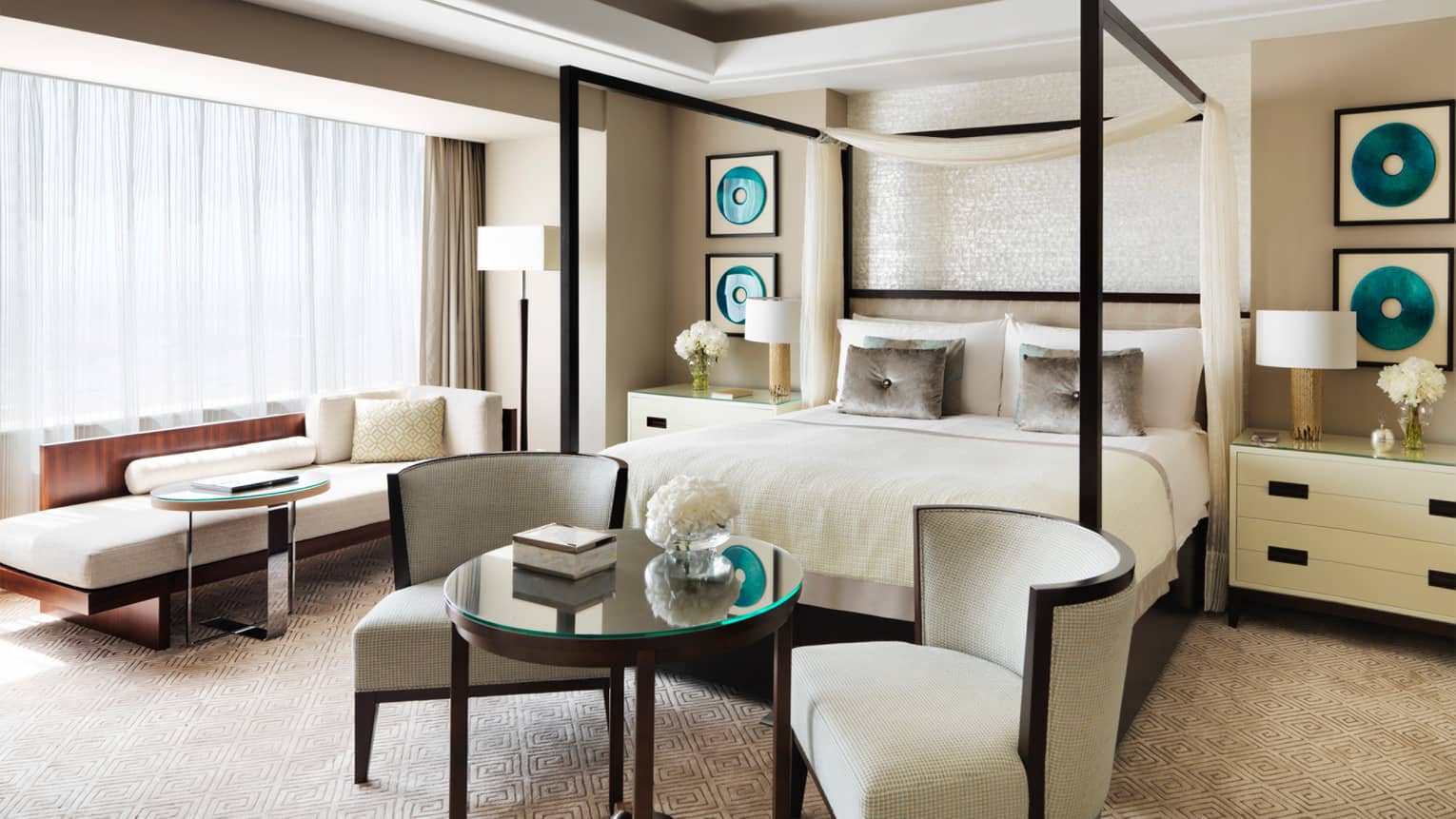 Royal Suite white bed with canopy, two white chairs and table at foot, chaise in front of window with curtains