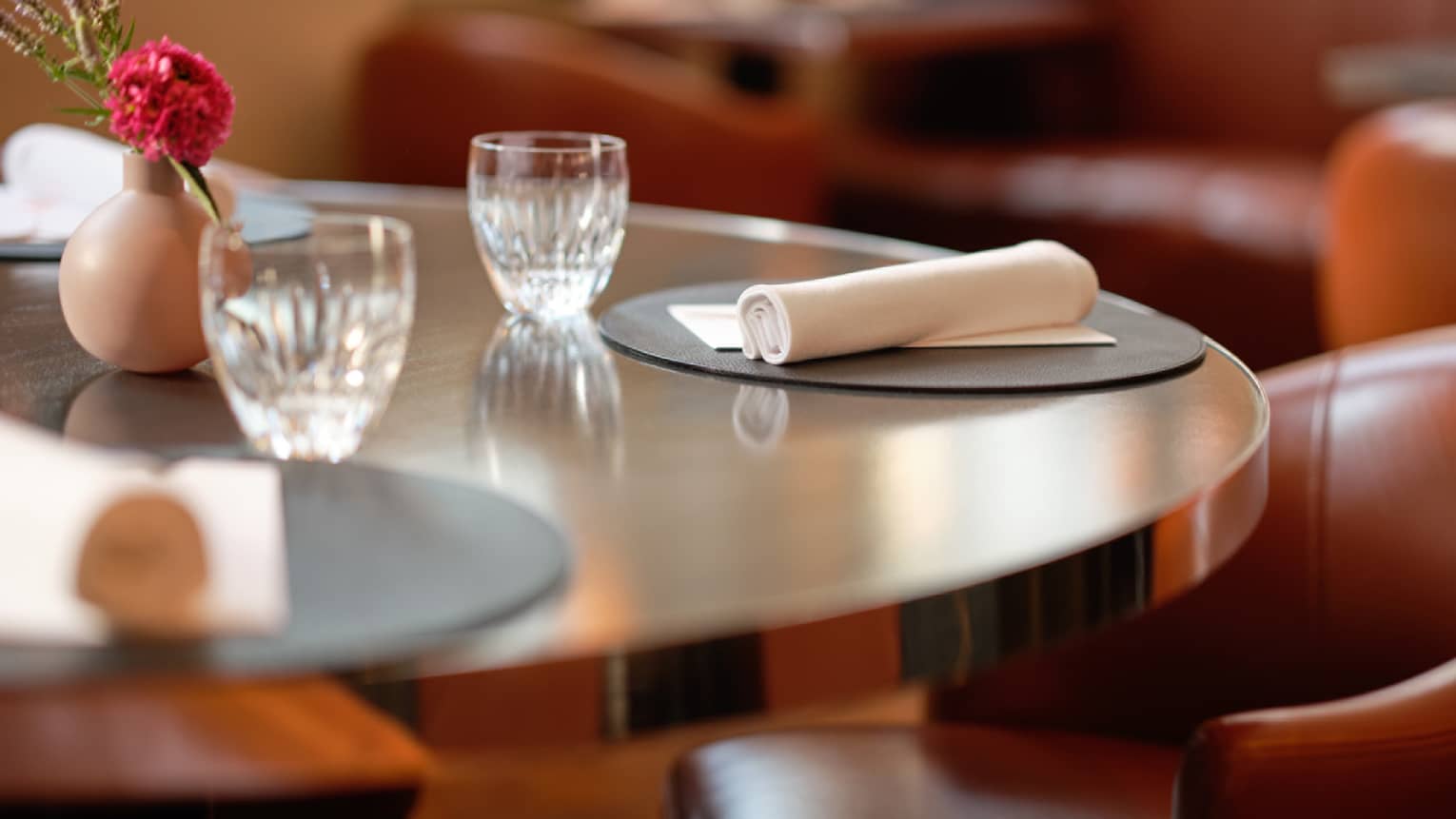Simply set round dining table with posy in vase in center