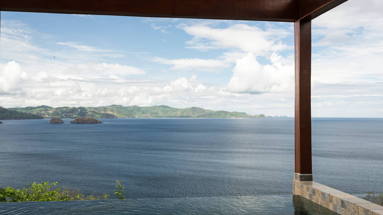 Canopy Plunge Pool Suite with sweeping views of ocean, mountain from edge of private infinity swimming pool