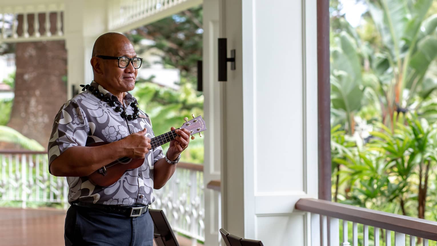 K?naka Maoli elder plays the ukelele on the second-story wraparound porch of the Resort