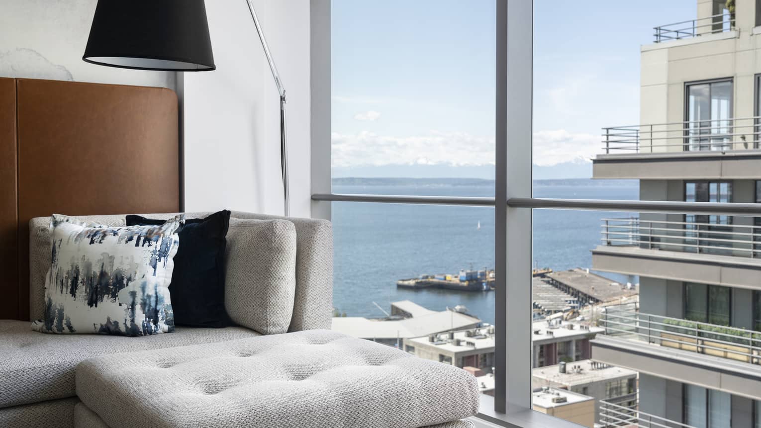 Blue water and a dock with boats can be seen from the windows of the Partial Bay View Room