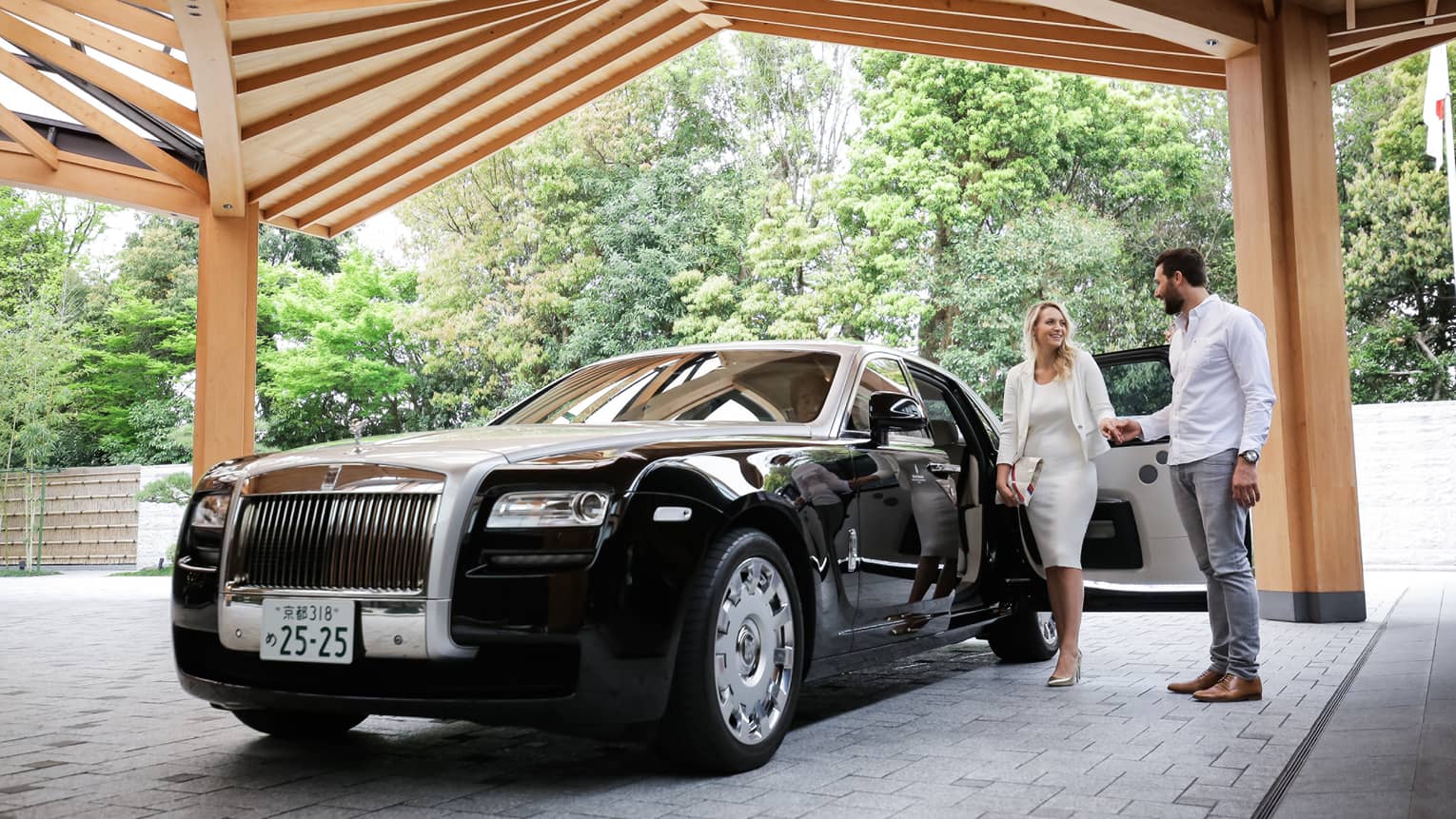 Couple exits black Bentley under awning at Four Seasons Hotel Kyoto