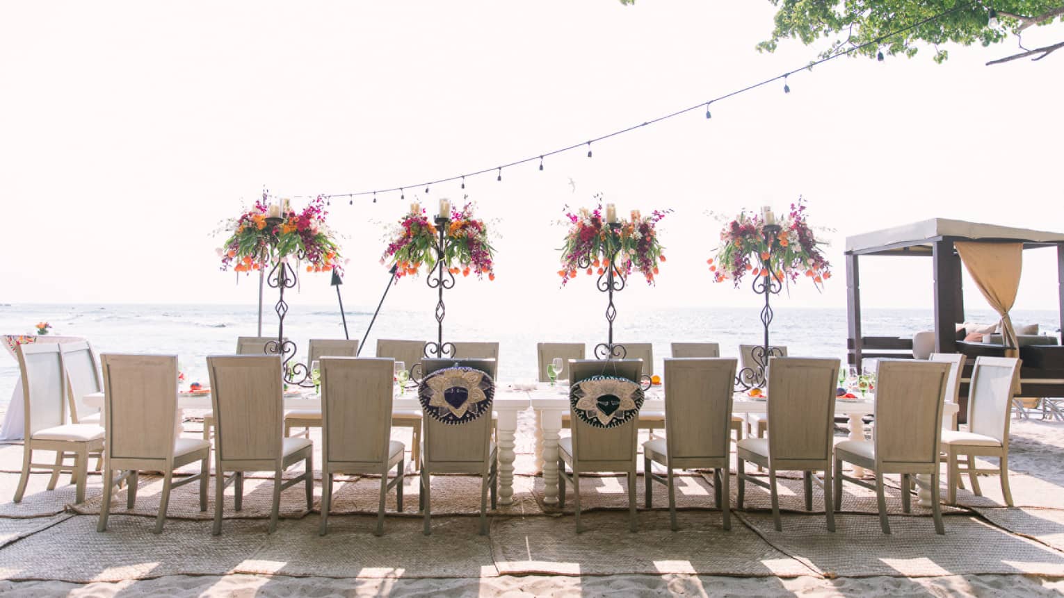 Chairs line sunny outdoor patio dining table with floral arrangements
