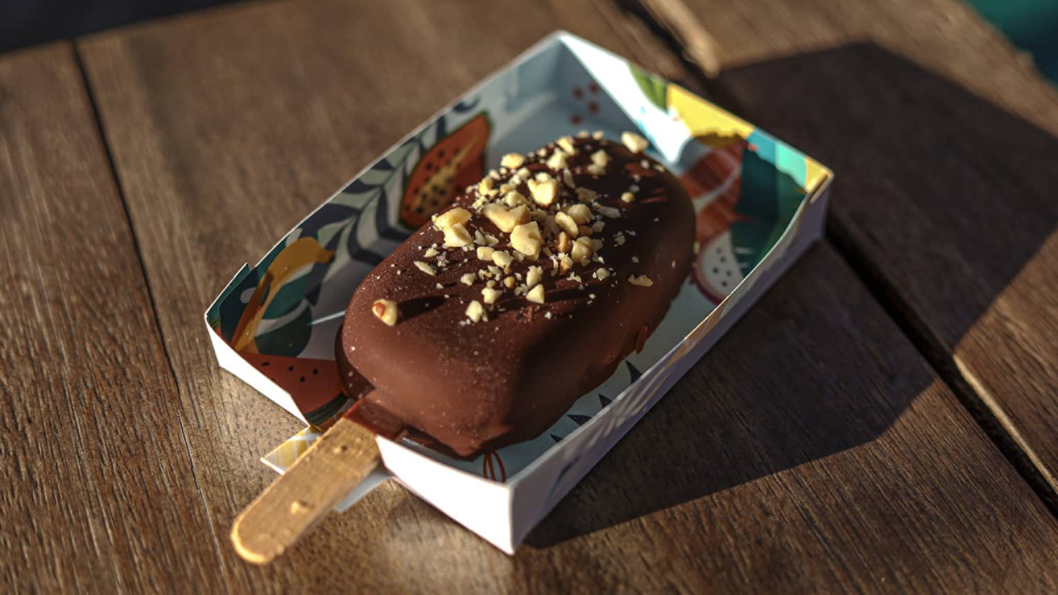 Chocolate-covered ice cream on a stick with peanut crumbles on top