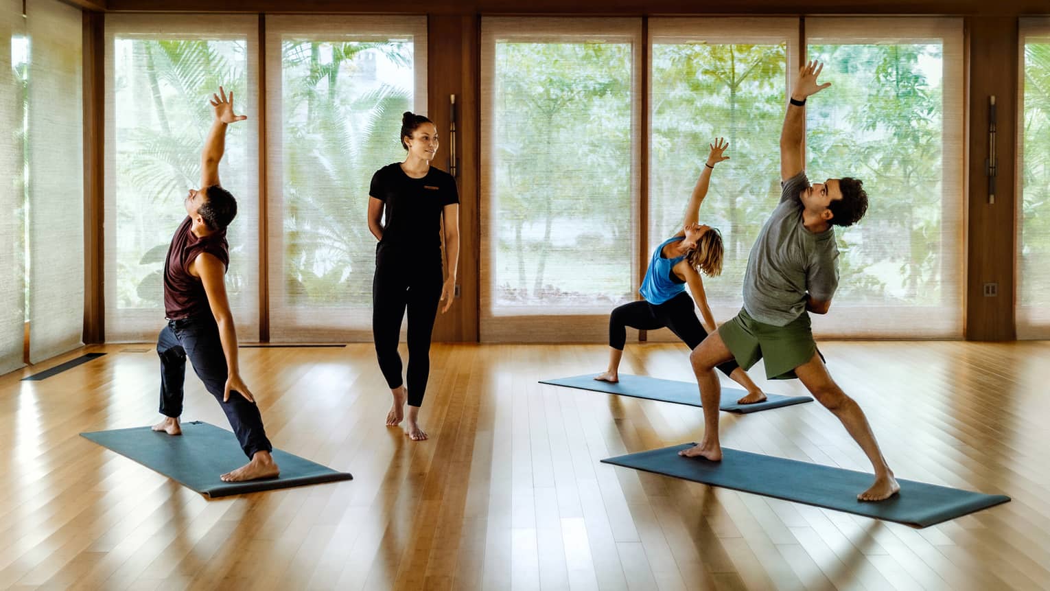 Yoga class with three people and instructor in soothing spa hale