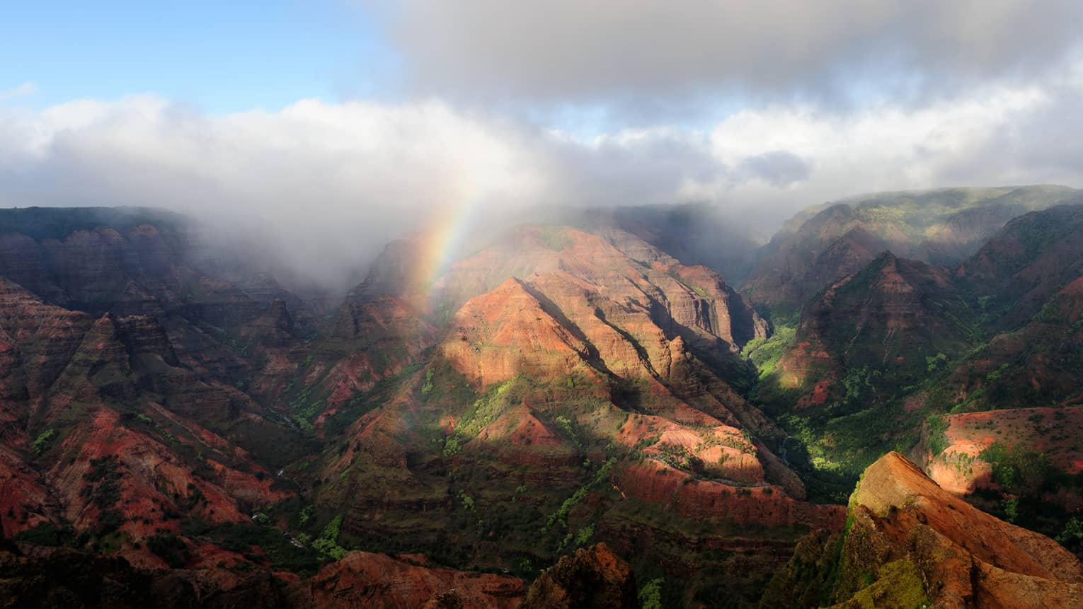 Sweeping views of The Waipi'o Valley Lookout mountains with clouds, rainbows