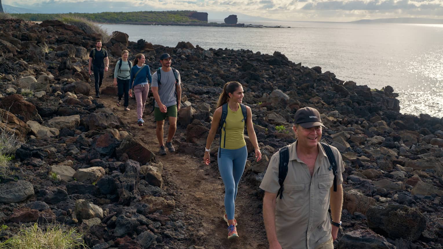 A group hikes along Hawaiian coastline