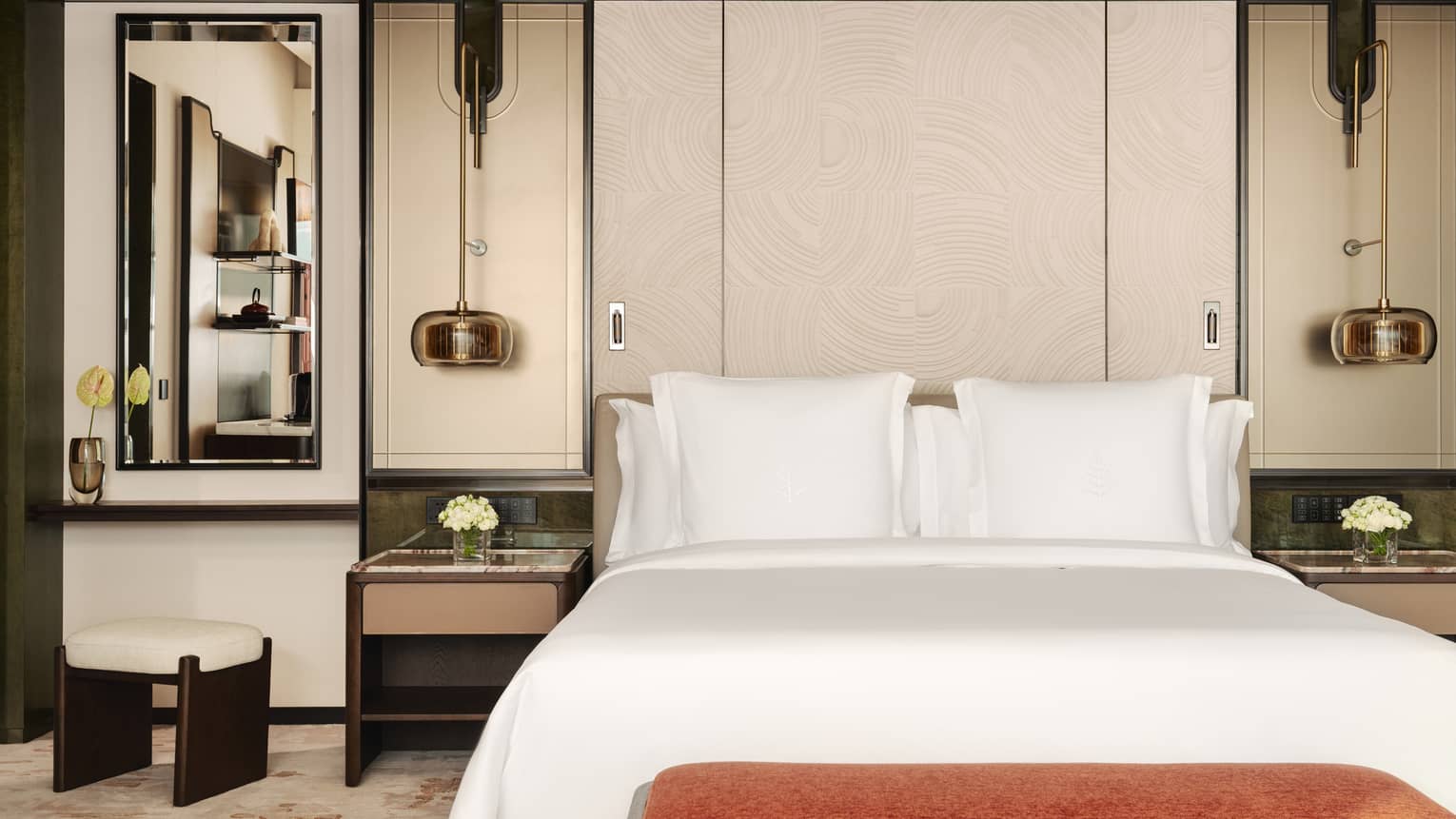 Hotel room king bed, with two side tables and hanging light fixtures