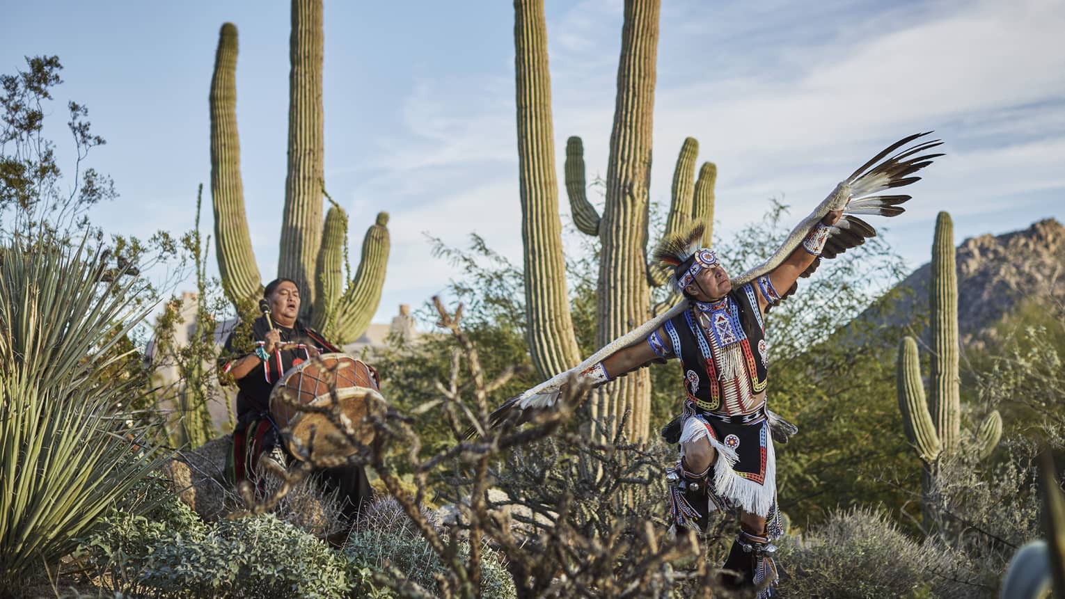 Native American drummer and Hoop Dancer perform by cacti