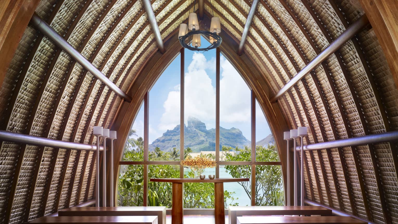 Arched roof of Aherenona chapel with end window looking over resort, lagoon and mountain