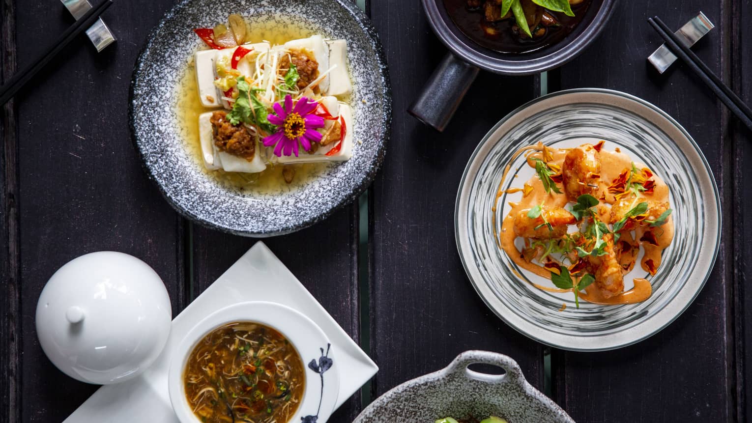 Five colourful dishes made of veggies and flowers on a dark wooden table at Cafe' Landaa