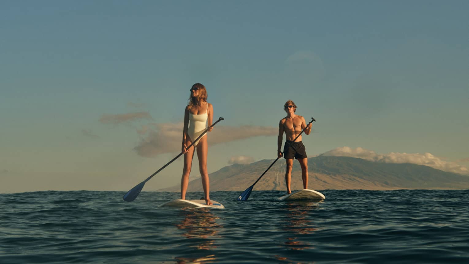 Two people stand-up paddleboarding