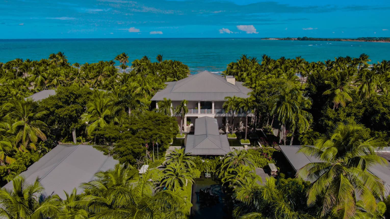 Aerial view of residence, lush jungle and ocean