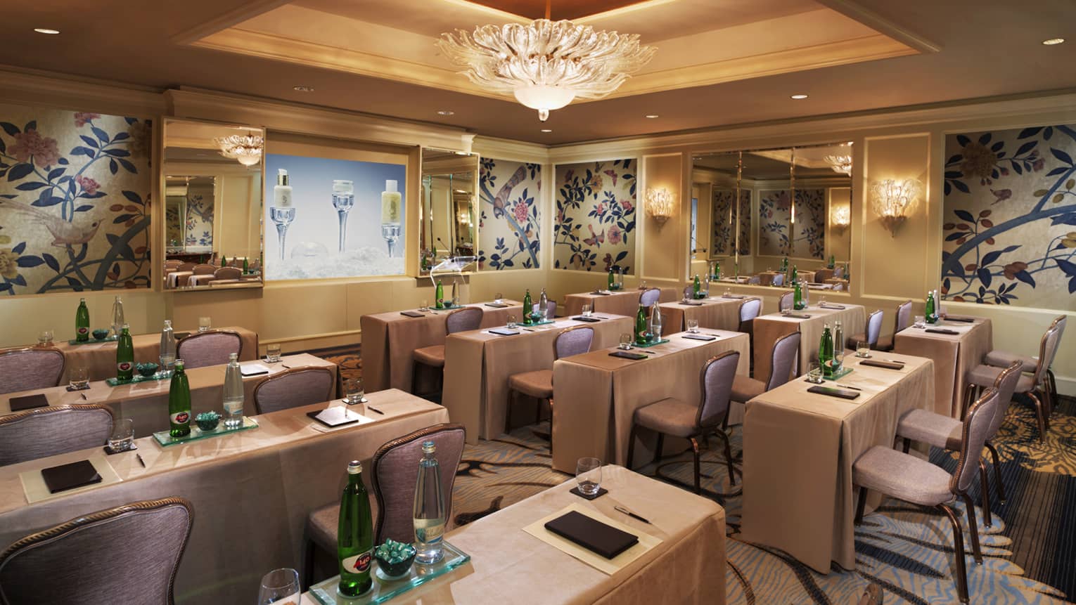 Eliska Meeting Room, rows of meeting tables, chairs under small crystal chandelier