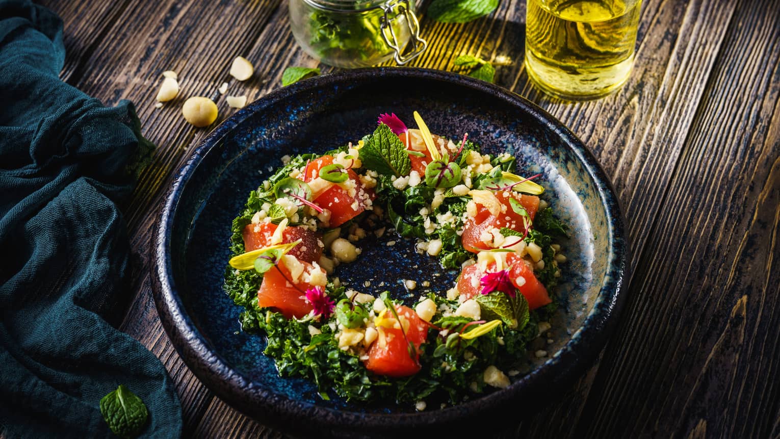 A black dish with greens and watermelon arranged in a circle.