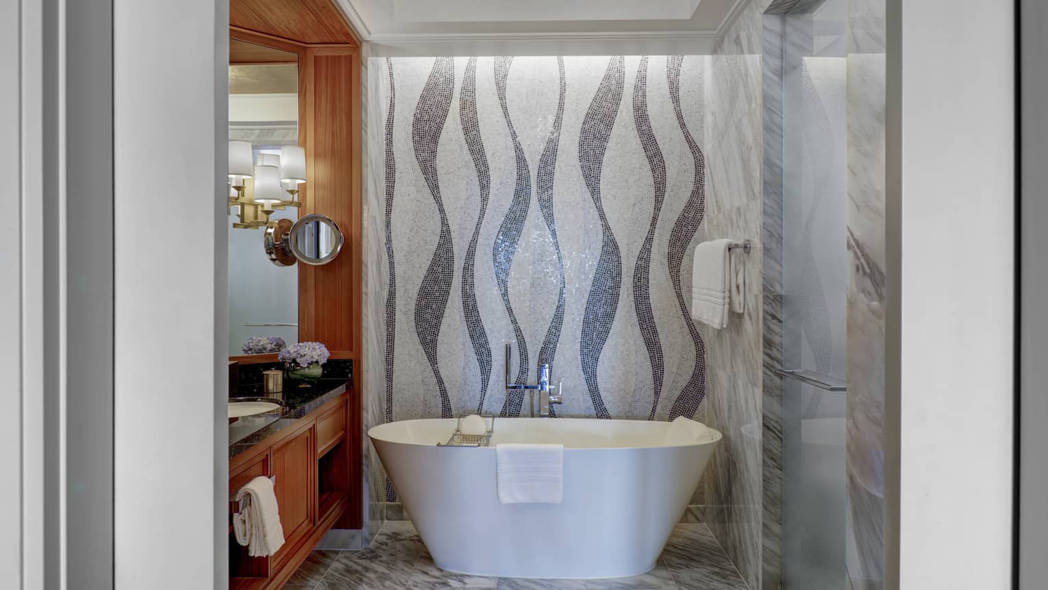 Bathroom with mosaic tiled wall, freestanding white tub