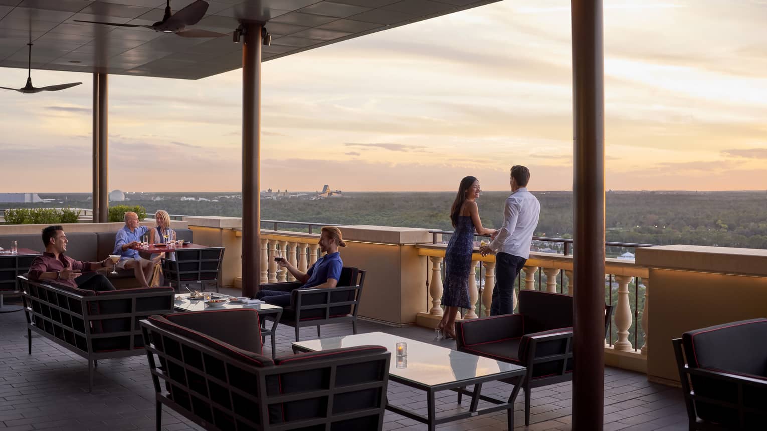 People lounge on Capa Bar terrace under roof at sunset