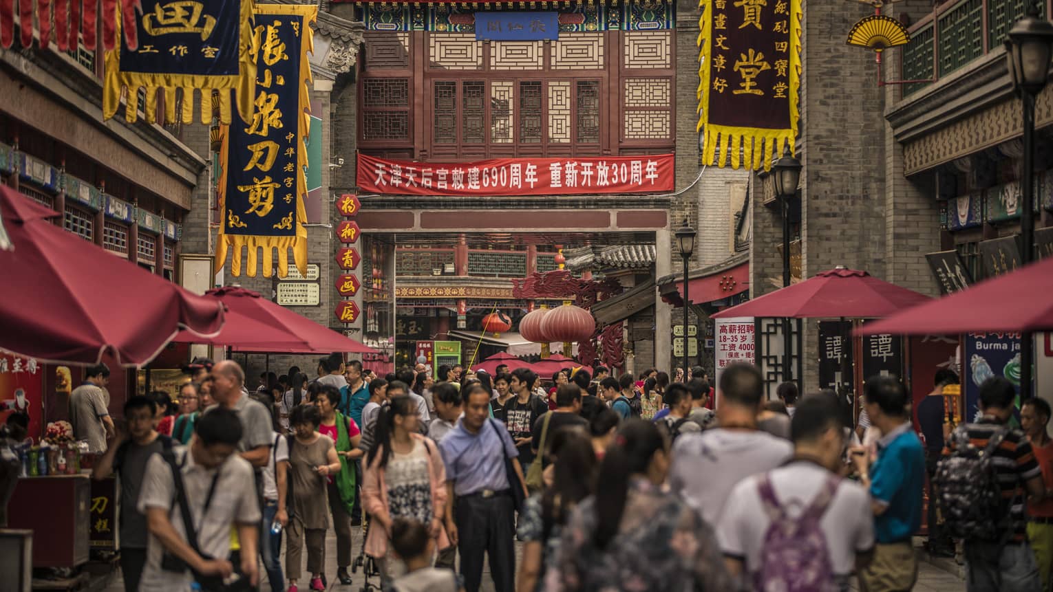 People walk through crowds on busy Tianjin street