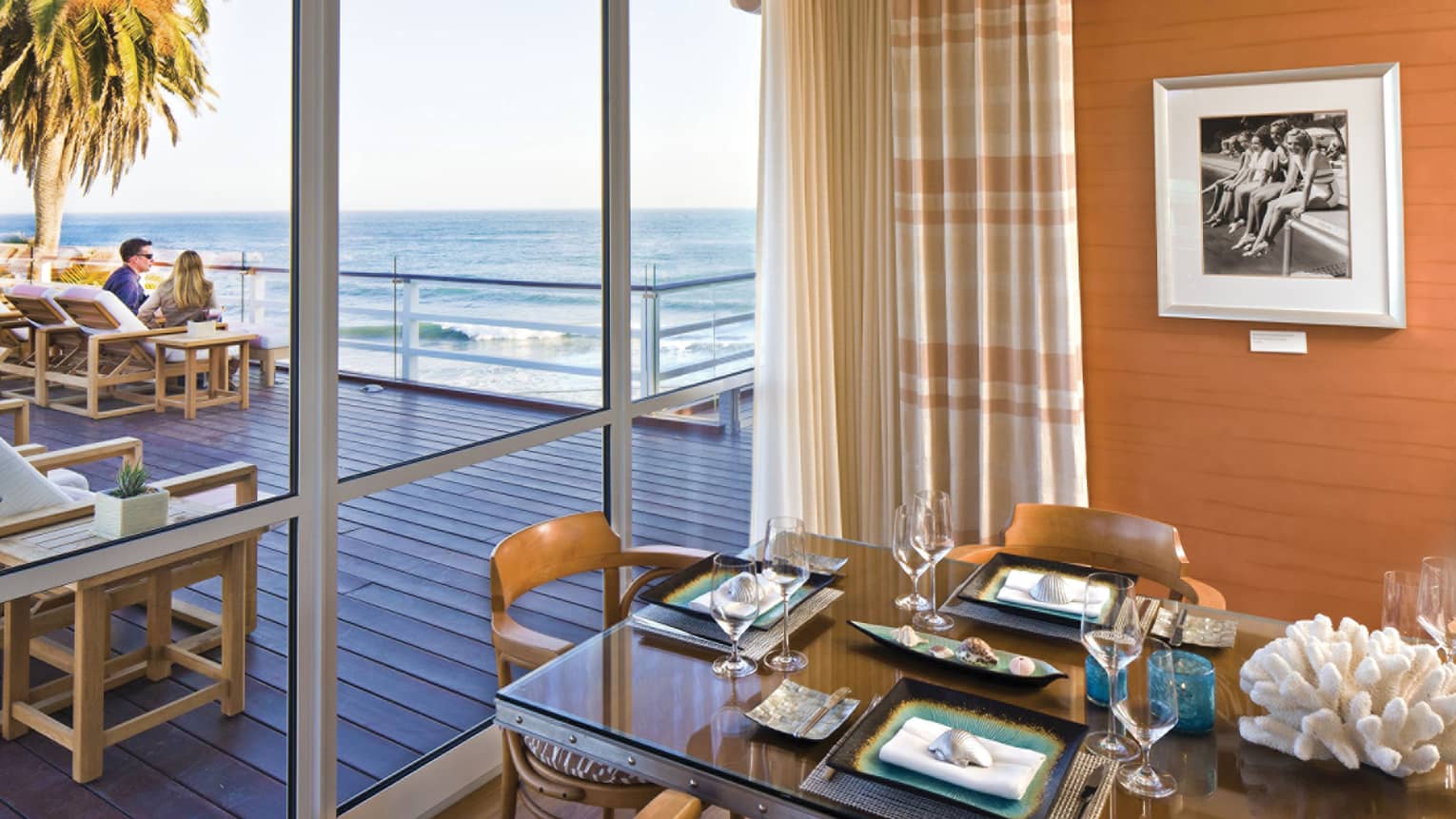 Private dining table next to glass sliding doors, couple on patio