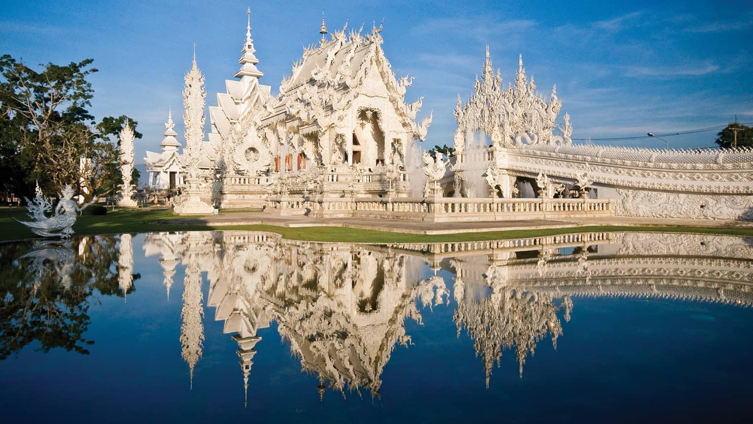 An ornate white castle reflecting in a pond