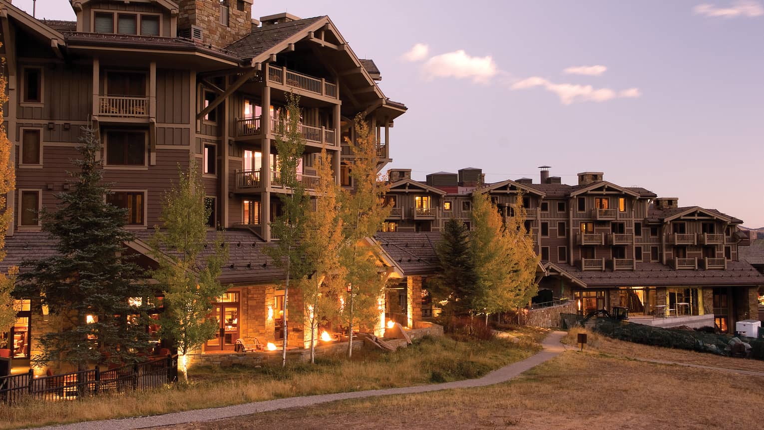 Four Seasons Jackson Hole Mountain Resort lodge exterior with lights at dusk