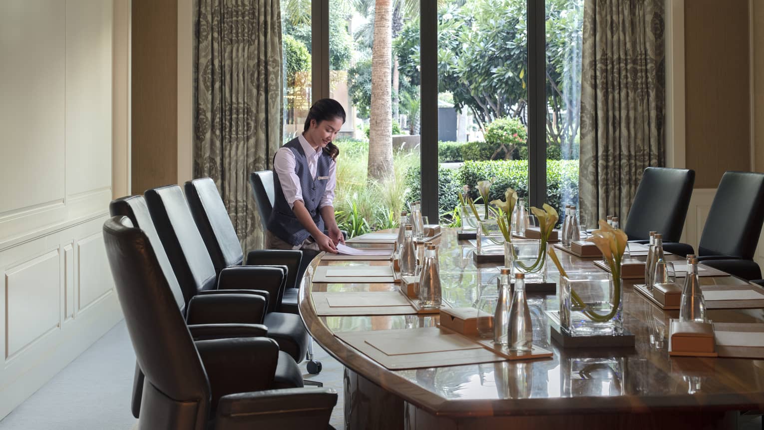 Events staff arranging a boardroom meeting with view of gardens behind