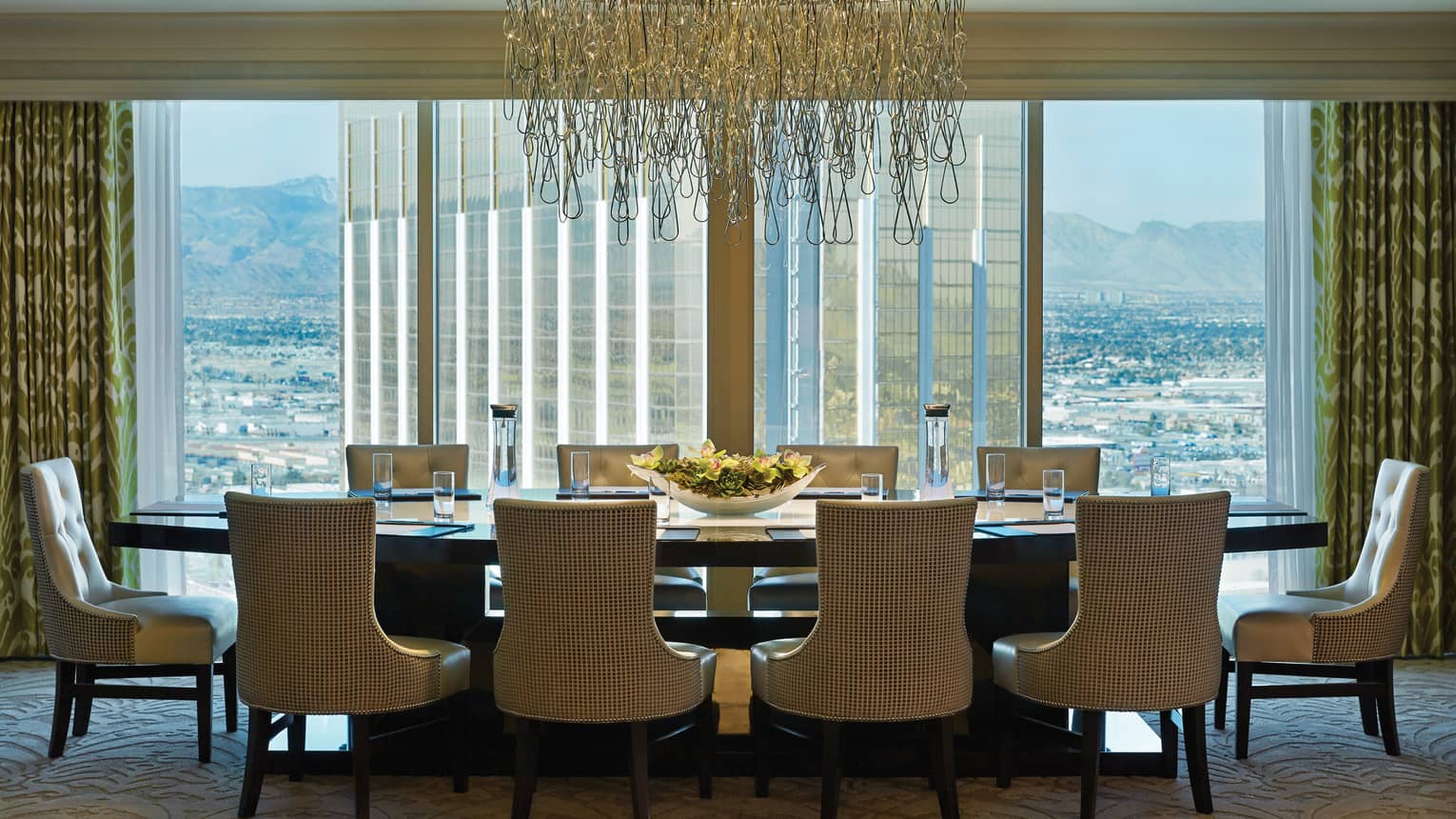 Private dining table under modern artistic chandelier by floor-to-ceiling windows 